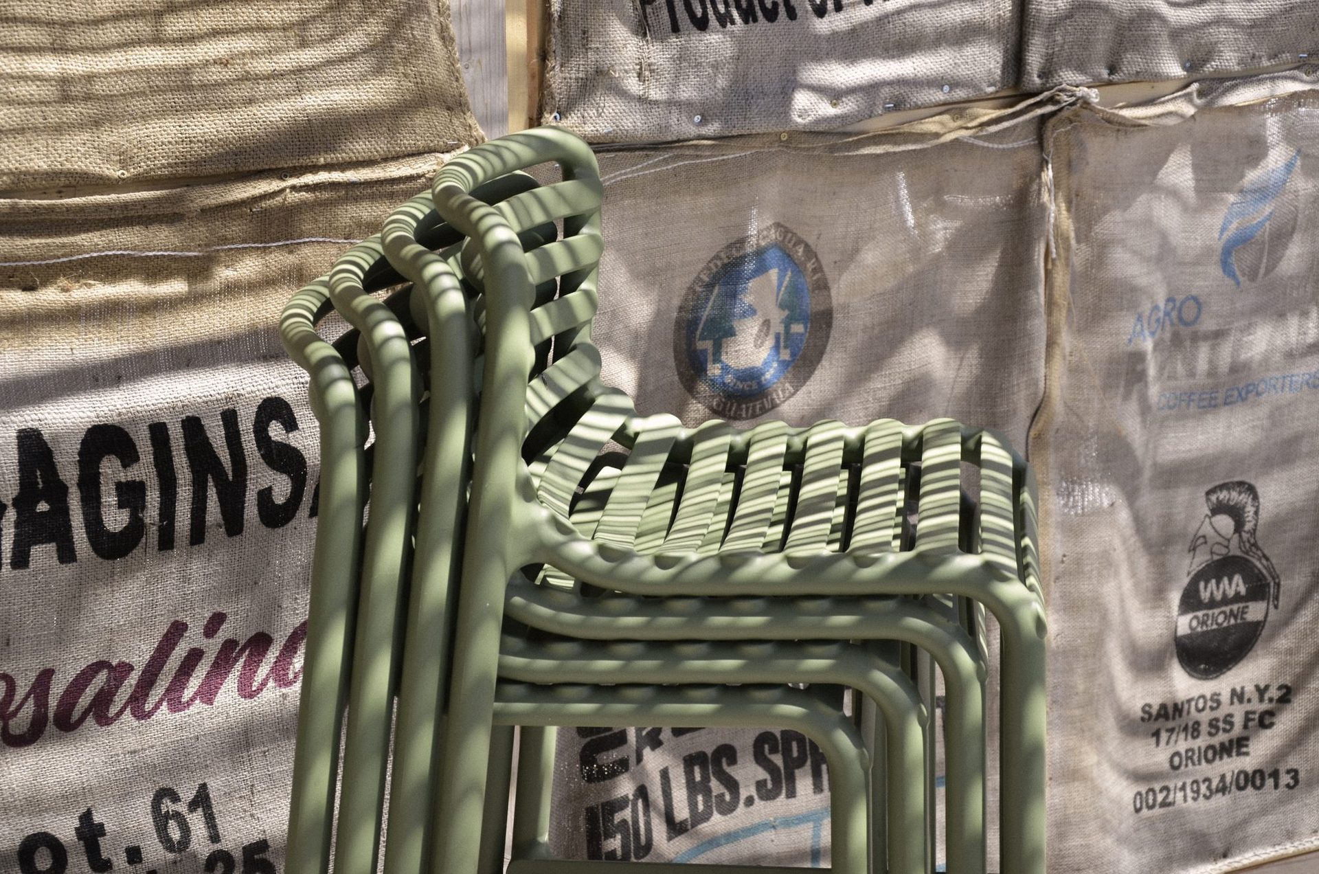 Chaises Nardi Doga empilées sur fond de sacs de café